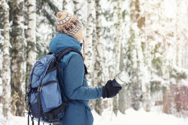 Erkek sırt çantası ve termos sıcak giysiler uzun yürüyüşe çıkan kimse karlı kış ormanda seyahat. Mevsimlik açık seyahat kavramı. Kopya alanı.