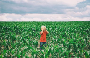 Şirin Bebek sarışın çocuk gözleri elleriyle kapalı ile sahada duruyor. Oyun gizlemek. Beni bul..