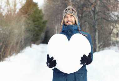 Kocaman bir kalbin tutan çekici gülümseyen adam wint karda yapılmış