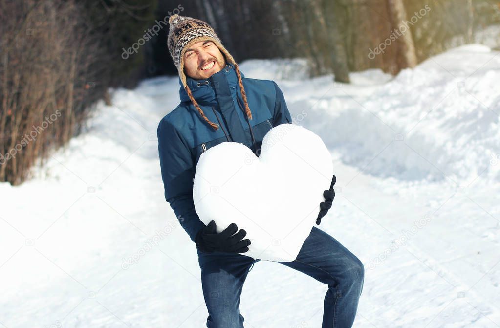 Comical man with great difficulty holding huge heavy heart made 