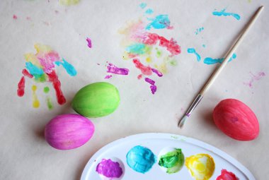 Boyama paskalya yumurtası. Paletteki boyalar, renkli yumurta ve çocuk p