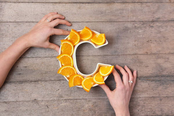 Vitamin C nutrient in food concept. Woman hands holding plate in