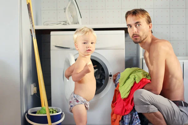 Jonge vader en zijn peuter blonde zoon in de Wasserij vangen door su — Stockfoto