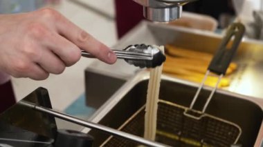 Sokak gıda satıcısı bir makineiçine hamur sıkma churros hazırlar. Churro İspanyol geleneksel donut olduğunu.