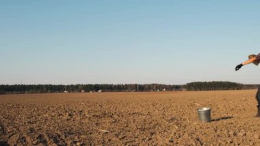 Komik çiftçi adam taze sürülmüş bir alana mızrak gibi kürek atar. Yavaş çekim.