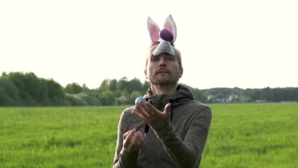 Funny Adult Man Bunny Mask Juggles Colored Painted Eggs Green — Stock Video