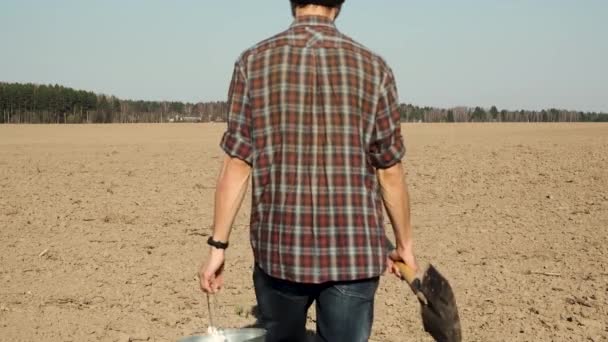 Male Farmer Shovel Bucket Goes Freshly Plowed Field Stops Looks — Stock Video
