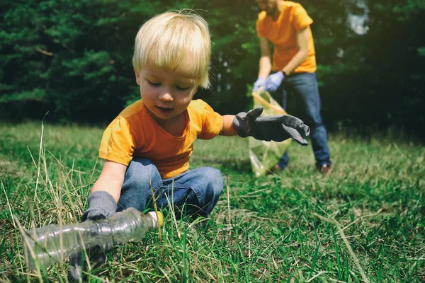 Militants bénévoles enfant et son père dans des gants rangeant les ordures dans le parc ou la forêt. Sauver le concept d'environnement. Arrêter la pollution plastique . — Photo