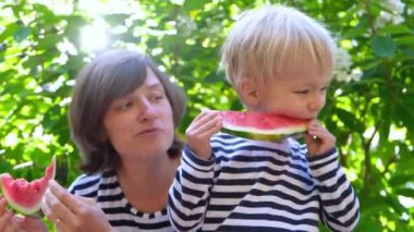 Gerçek anne ve oğlu birlikte yaz aylarında, oyun ve dışarıda karpuz yeme.