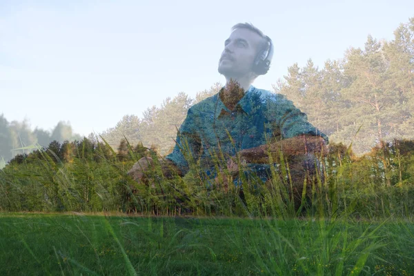 Handsome young bearded man sitting wearing headphones and listen to relaxation music on nature on sunset. Double exposure. Sonic Therapy. — Stock Photo, Image