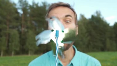 Komik yetişkin sakallı adam oyuncak rüzgar türbini üfleme. Baba fırıldak nasıl çalıştığını göstermek.