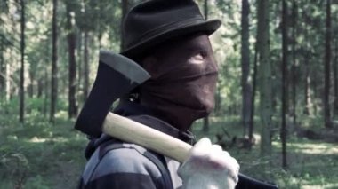 Ormanda baltalı bir seri katil öldürmek için birini arıyor. Kanlı katil, katil, korkunç maskeli çılgın adam. Çirkin sırıtışı ve çılgın gözleri var. Cadılar Bayramı kostümü, korku konsepti.