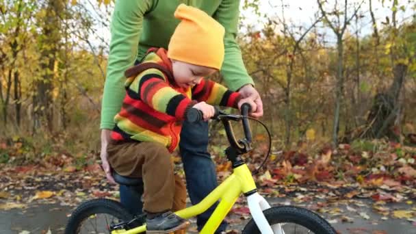 Far Lär Sitt Lilla Barn Att Cykla Höstparken Lyckliga Familjeögonblick — Stockvideo