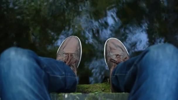 Pria Pov Kaki Sepatu Sneakers Tergantung Dari Jembatan Atas Sungai — Stok Video