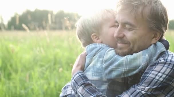 かわいい幼児の男の子は父親の屋外で抱き合ってキスしています 優しさ 父と息子の関係 父の日の概念 幸せな家族の瞬間 — ストック動画