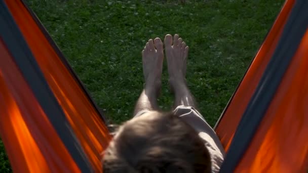 日落时 人类躺在大自然的吊床上 远足的感觉 乡村生活的缓慢 户外放松 暑假的概念 从后面看 — 图库视频影像