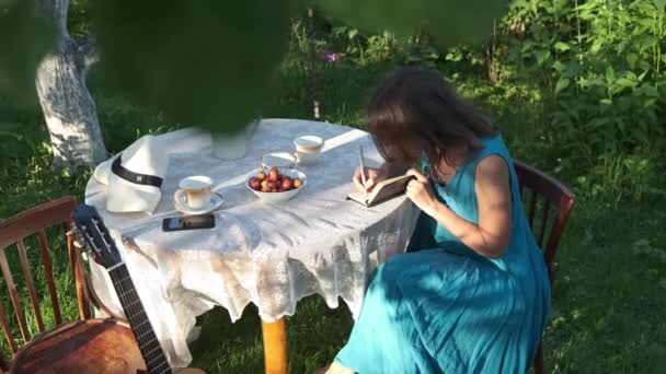 Düşünceli Kadın Arka Bahçedeki Bahçe Masasında Oturur Deftere Alır Günlük — Stok video