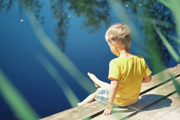 Menino Feliz Sentado Cais Madeira Perto Lago Summy Dia Verão — Fotografia de Stock
