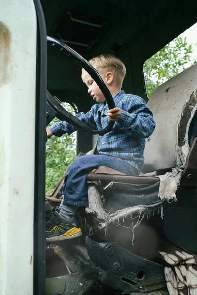 古いヴィンテージトラックの車の中で遊んで幸せな小さな子供の少年は 大きなホイールを保持します 田舎でのスローライフ 幸せな子供時代のコンセプト — ストック写真