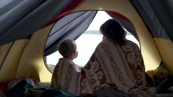 母亲和儿子坐在帐篷里 裹着毛毯 在河边欣赏日出 家庭周末户外 当地的自然旅行 徒步旅行 营地生活方式 — 图库视频影像