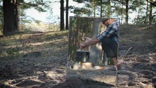 松树林篝火上男性观光客烹调食物的镜像反思 积极的户外生活方式概念 — 图库视频影像