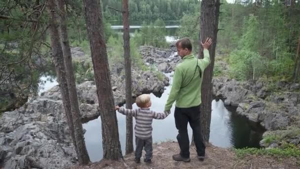 Widok Tyłu Ojciec Syn Turystów Stojących Klifie Pobliżu Górskiej Rzeki — Wideo stockowe