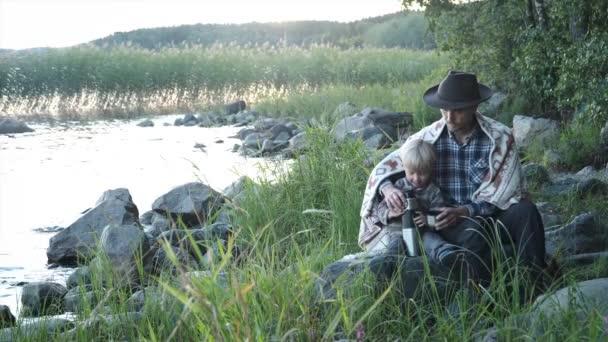 Rodzinny Piknik Naturze Ojciec Syn Siedzą Przy Jeziorze Zachodzie Słońca — Wideo stockowe