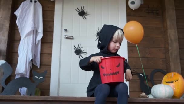 Lindo Niño Pequeño Disfrazado Halloween Sentado Porche Casa Sosteniendo Cesta — Vídeos de Stock