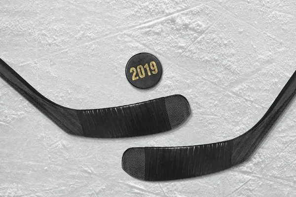 Дві хокейні палички і шайба на льоду — стокове фото