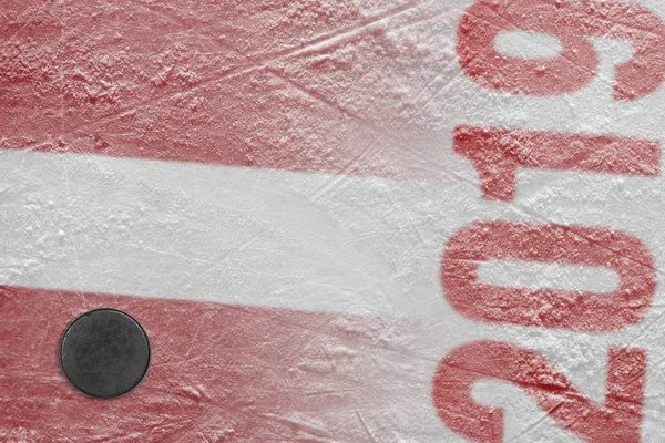 Disco da hockey sdraiato sul ghiaccio dell'arena con l'immagine del — Foto Stock