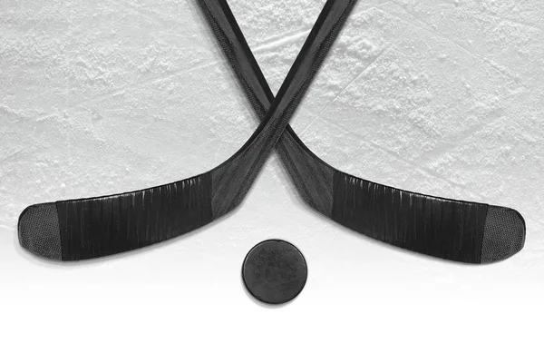 Deux bâtons de hockey et une rondelle sur la glace — Photo