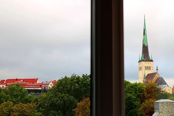 View through the window: the station (left) and the church of Oleviste (St. Olaf) - right - in Tallinn, Estonia