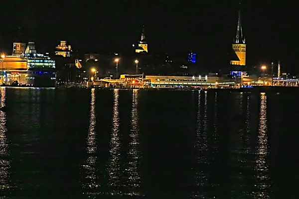 Uitzicht op de oude stad van Tallinn, kerk van Sint-Olaf en de voering van de cruise in de nacht, Estland — Stockfoto