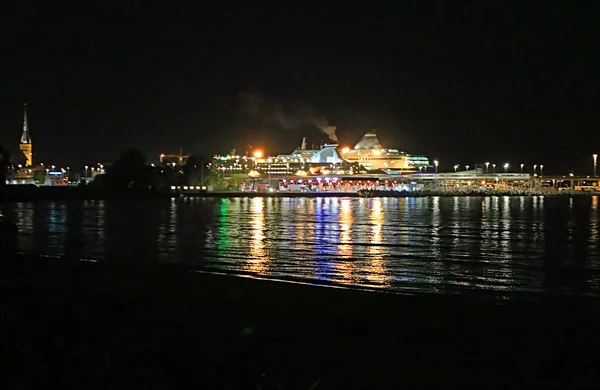 Uitzicht op de oude stad van Tallinn, kerk van Sint-Olaf en de voering van de cruise in de nacht, Estland — Stockfoto