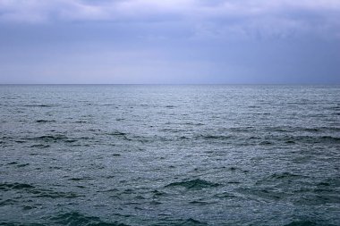 Yağmurdan sonra bulutlu mavi gökyüzü ile Akdeniz manzarası. Larnaka sahilinde dalgalar ve rüzgar