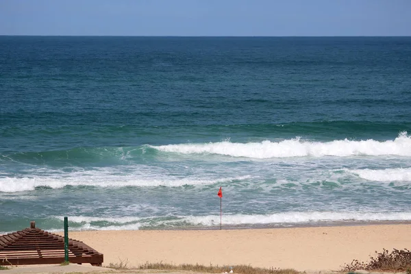 View of Mediterranean sea. Red flag on sand beach for warning of dangerous of swimming in the sea in Ashkelon, Israel — Stock Photo, Image