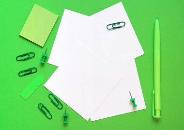 Yeşil arka plan üzerine kalem, kağıt ve kırtasiye. Yeşil tarzda. Sürdürülebilir iş kavramı. Düz yatıyordu, üstten bak. Metin için yer