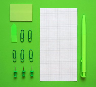 Yeşil arka plan üzerine kalem, kağıt ve kırtasiye. Yeşil tarzda. Sürdürülebilir iş kavramı. Düz yatıyordu, üstten bak. Metin için yer