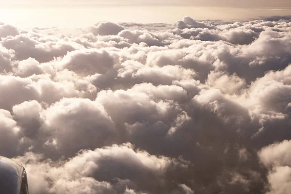 Uçakta gökyüzü manzarası. Akşamları dramatik ışık ile bulutların üzerinde güzel gökyüzü. Kabin görünümü ve uçak motoru. Altın saatler — Stok fotoğraf