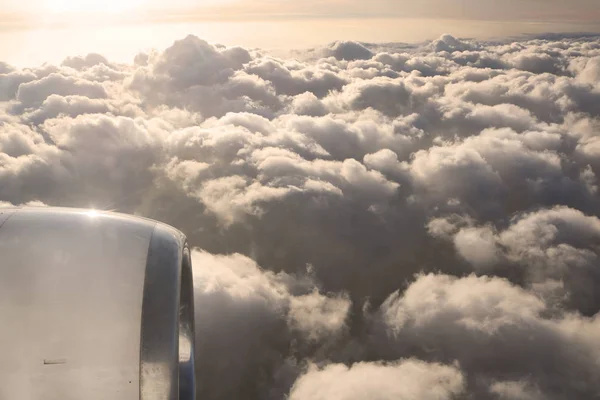 Sky view on the plane. Beautiful sky above clouds with dramatic light in the evening. Cabin view and airplane engine. Golden hours — Stock Photo, Image