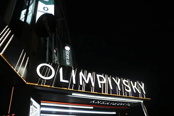 KYIV, UKRAINE -  AUGUST 04, 2019: Signboard Olimpiysky mall and business centre in the centre of the city on the coner of Phiskultury Street and Velika Vasilkovska near Metro station Olimpiyska at night — Stock Photo, Image