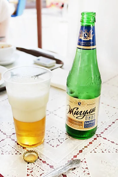 MOSCÚ, RUSIA - 05 DE JUNIO DE 2013: Vidrio de plástico con cerveza y una botella de cerveza Zhiguli sobre un mantel en un café estilizado bajo los años 70 - 80. Este nombre de cerveza es el mismo que el de la famosa marca de automóviles de la era soviética en los años 80. —  Fotos de Stock