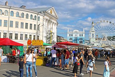 Kiev, Ukrayna - 13 Temmuz 2019: Fuardaki insanlar Made In Ukraine on a food zone, hafta sonu sokak pazarı festivali, el sanatları fuarları ve Kiev-Mohyla Akademisi Ulusal Üniversitesi görünümü (solda))