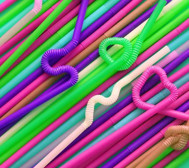 Esnek bir parçaya sahip renkli plastik kokteyl tüpleri, düğüme veya zikzak şeklinde veya kalp şeklinde bükülebildiği için. Modern ve neon moda renkler. Eko kavramı