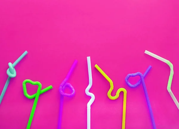 Цветные пластиковые коктейльные трубки с гибкой частью, благодаря чему они могут быть скручены в узел или зигзагом, или в форму сердца, на багровом фоне. Современные и модные цвета. Принято. Эко-концепция — стоковое фото