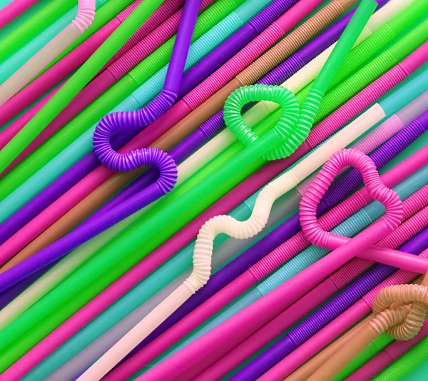 Цветные пластиковые коктейльные трубки с гибкой частью, благодаря чему они могут быть скручены в узел или зигзагом, или в форму сердца. Современные и неоновые модные цвета. Эко-концепция — стоковое фото