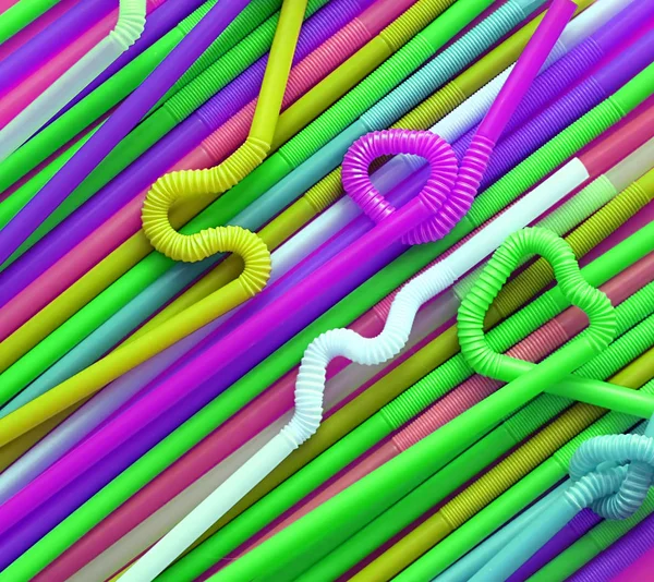Esnek bir parçaya sahip renkli plastik kokteyl tüpleri, düğüme veya zikzak şeklinde veya kalp şeklinde bükülebildiği için. Modern ve neon moda renkler. Eko kavramı