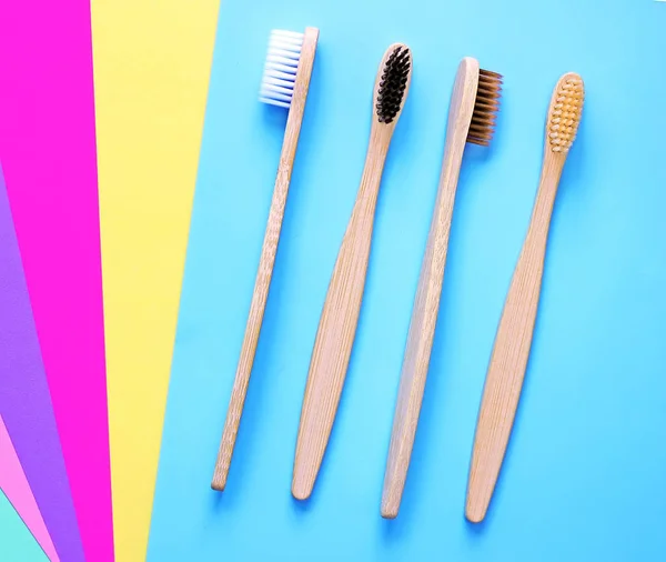 Bambu hammasharjat on monivärinen kirkas tausta trendikkäitä värejä. Ympäristöystävällisiä tuotteita. Eco, nolla jätteiden ja terveyden käsitteitä. Litteä pano. Tekstipaikka. Biohajoava materiaali — kuvapankkivalokuva