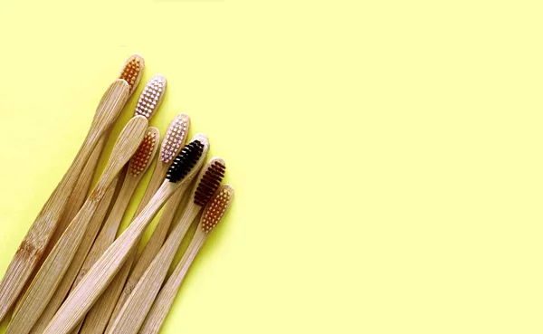 Bamboo toothbrushes on trendy yellow background. Eco-friendly products. Eco, zero waste and health concepts. Flat lay. Place for text. Biodegradable material — Stock Photo, Image