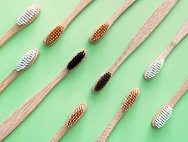 Bamboo toothbrushes on trendy green background. Eco-friendly products. Eco, zero waste and health concepts. Flat lay. Place for text. Biodegradable material — Stock Photo, Image
